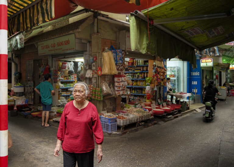 Photographer exploring Hanoi's narrow residential alleyways during the Life in the Lanes photo tour